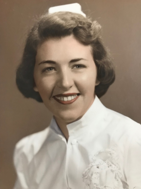 Portrait of Evelyn Gasster as a young nurse, smiling, in a white uniform and nurse's cap.